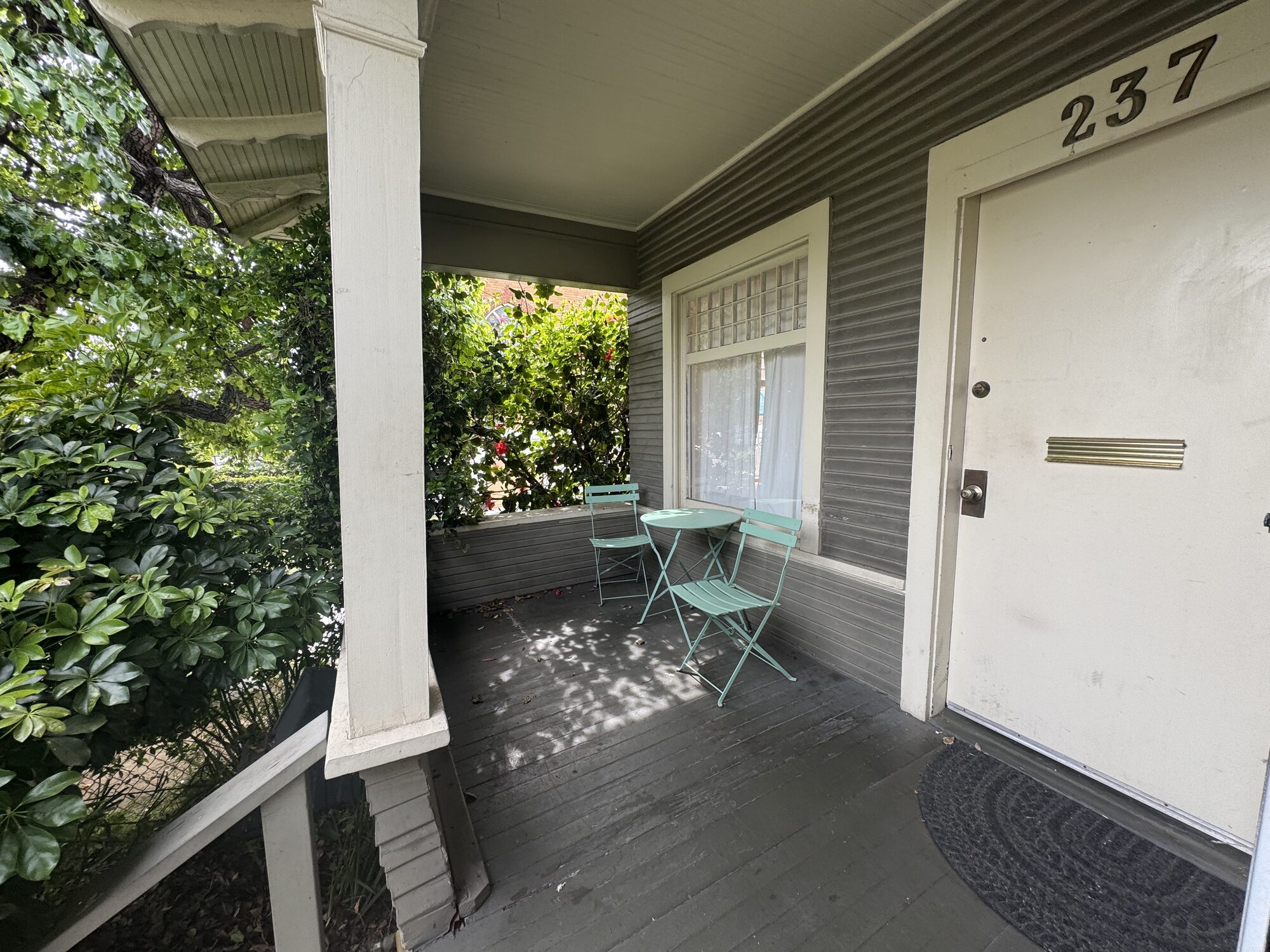 Covered Hill Street Center porch with tables and garden seating