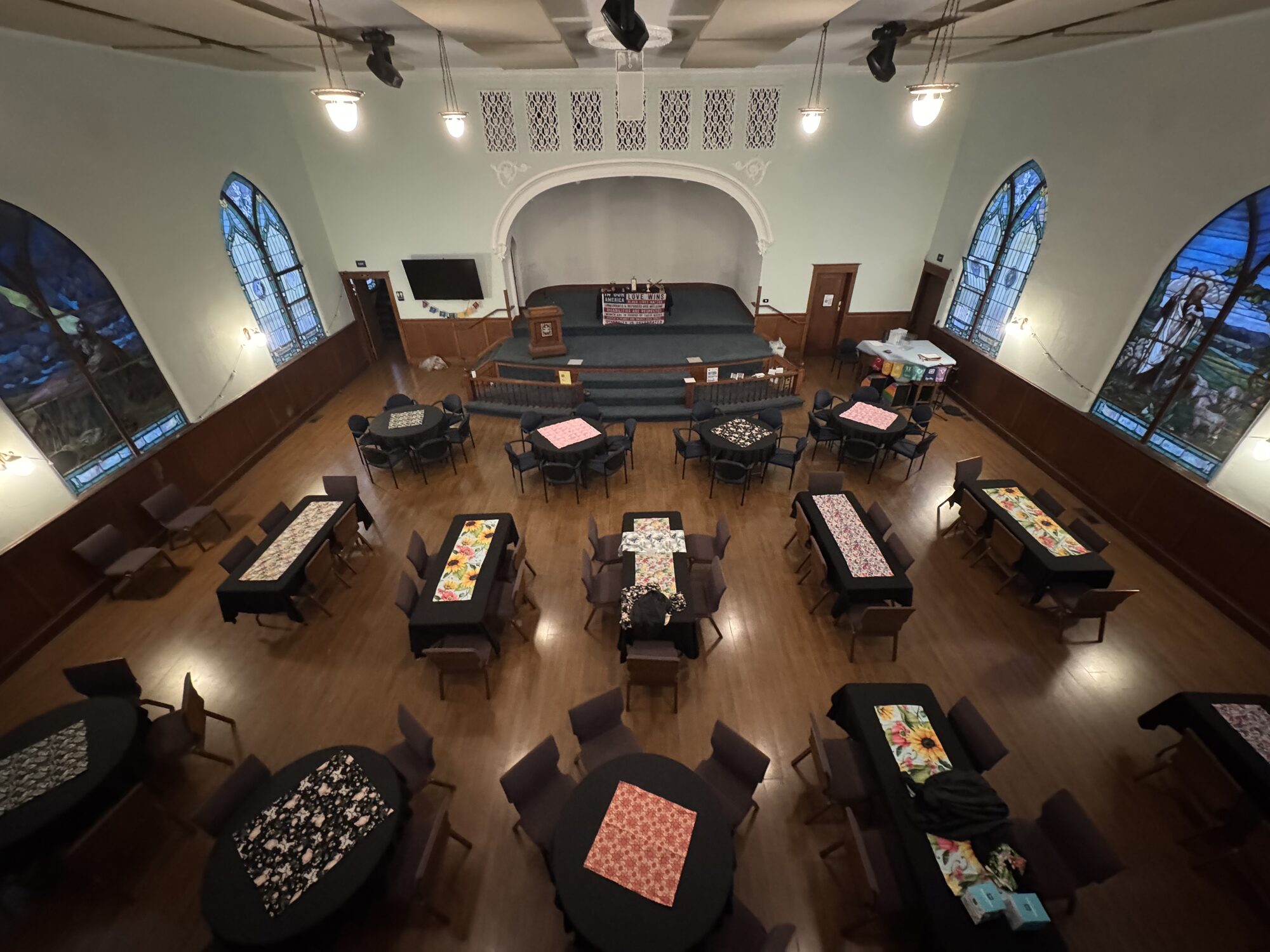 Main room arranged with round dining tables for a private event