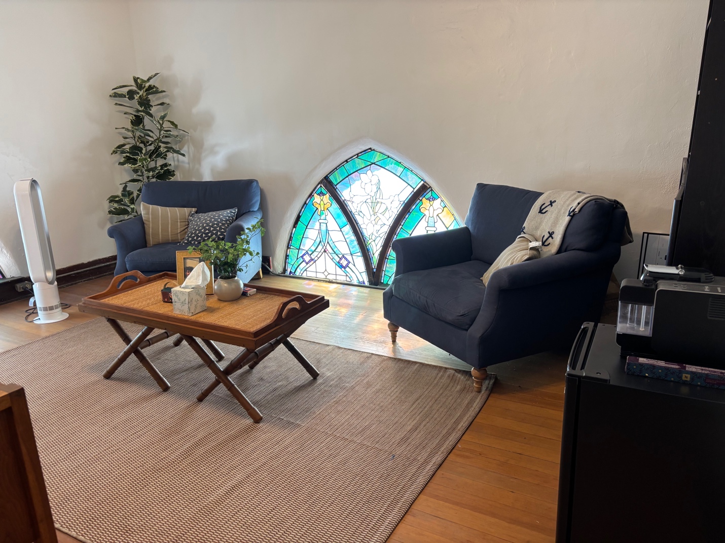 Upstairs office at Church in Ocean Park with blue armchairs, hardwood flooring and a stained-glass window